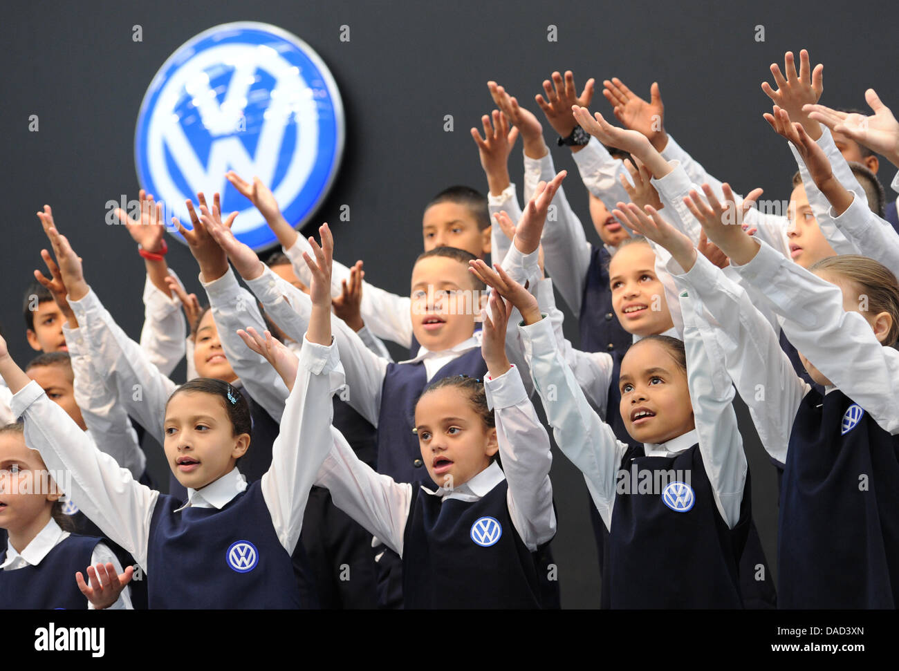 A group of children, wearing school uniforms featuring the VW car logo,  cheer and smiles during a visit of Lower Saxony's Premier, David  McAllister, to the Volkswagen plant Anchieta in Sao Bernardo