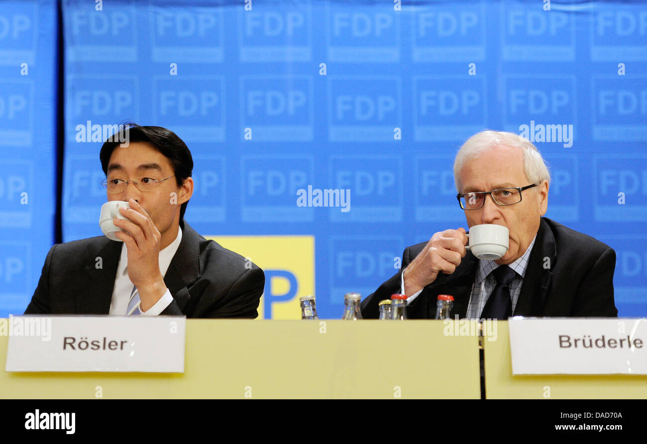Chairman of the Free Liberals (FDP) and Federal Economy Minister Philipp Roesler (L) and FDP fraction chairman in the German Bundestag Rainer Bruederle drink coffee during the regional conference of his party in Dortmund, Germany, 09 October 2011. Among others, the conference focusses the Euro bailout and the last election desasters. Photo: MARIUS BECKER Stock Photo