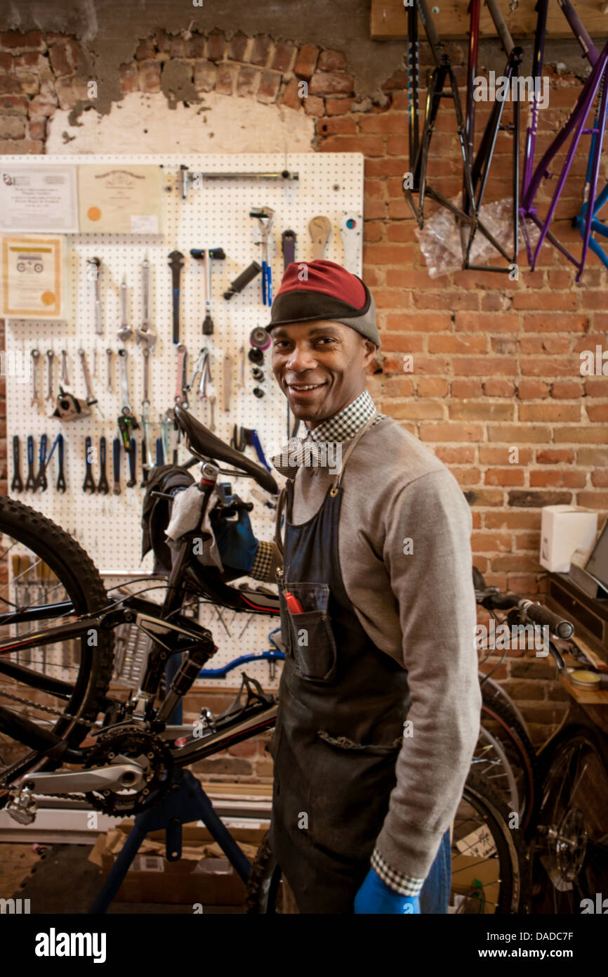 Satisfied mechanic holding up bicycle Stock Photo