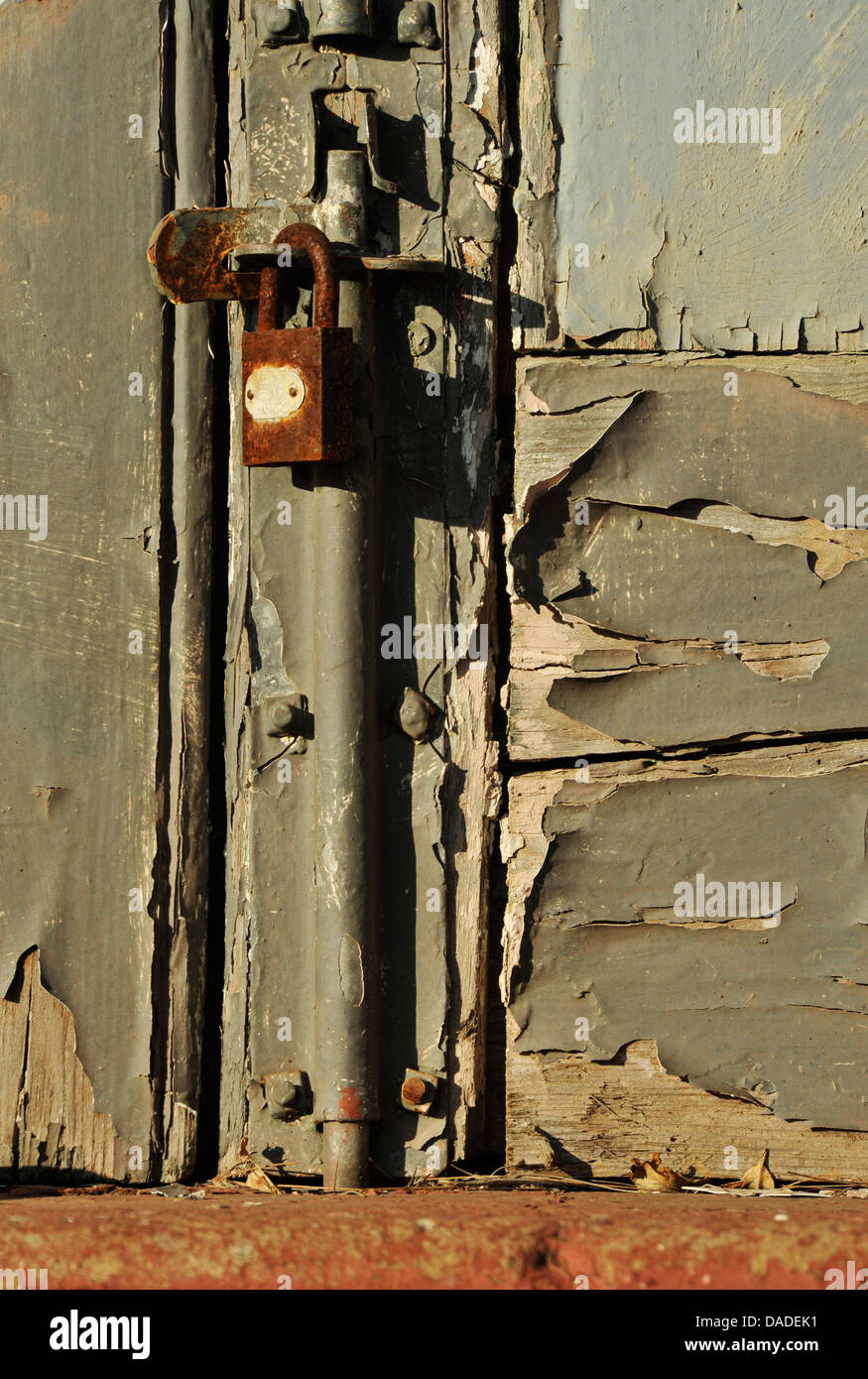 View of old door with rusted padlock and securing bolt with peeling grey paint Abstract Backgrounds Colours Stock Photo