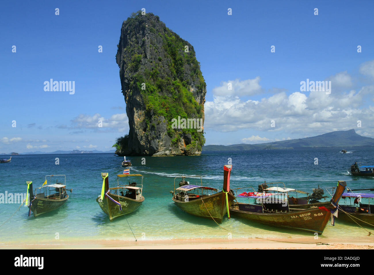 long-tail boats at the beach in front of grandiose karst rock formation, Thailand, Krabi, Laem Phra Nang Stock Photo