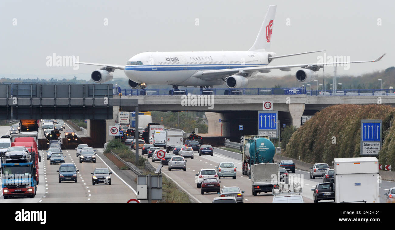 An Airbus 340-300x of Air China maneuvers across a bridge passing the A3 motorway heading on its way from the new runway torwards the terminal at the Rhine-Main airport in Frankfurt, Germany, 25 October 2011. The new runway was build within a period of just two years and is expected to increase the airport's capacity by 50 percent. Shortly before the start of operation the new airs Stock Photo