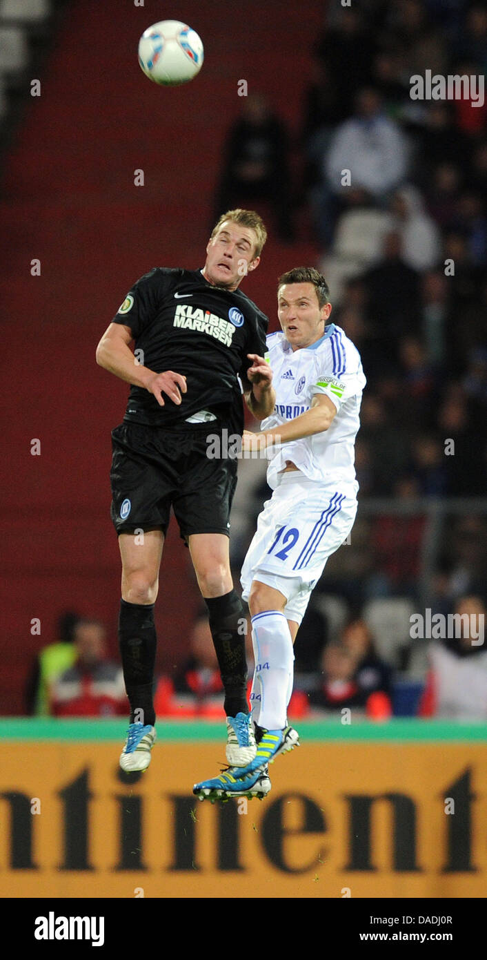 Karlsruhe's Klemen Lavric (L) and Schalke's Marco Hoeger are locked in a battle for the header during the DFB Cup match between Karlsruher SC and FC Schalke 04 at the Wildparkstadion in Karlsruhe, Germany, 26 October 2011. Photo: Uli Deck Stock Photo