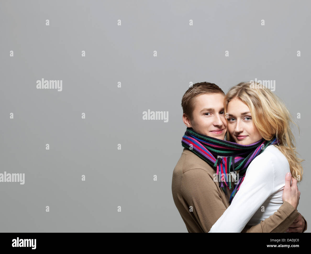 Young couple wearing same scarf Stock Photo
