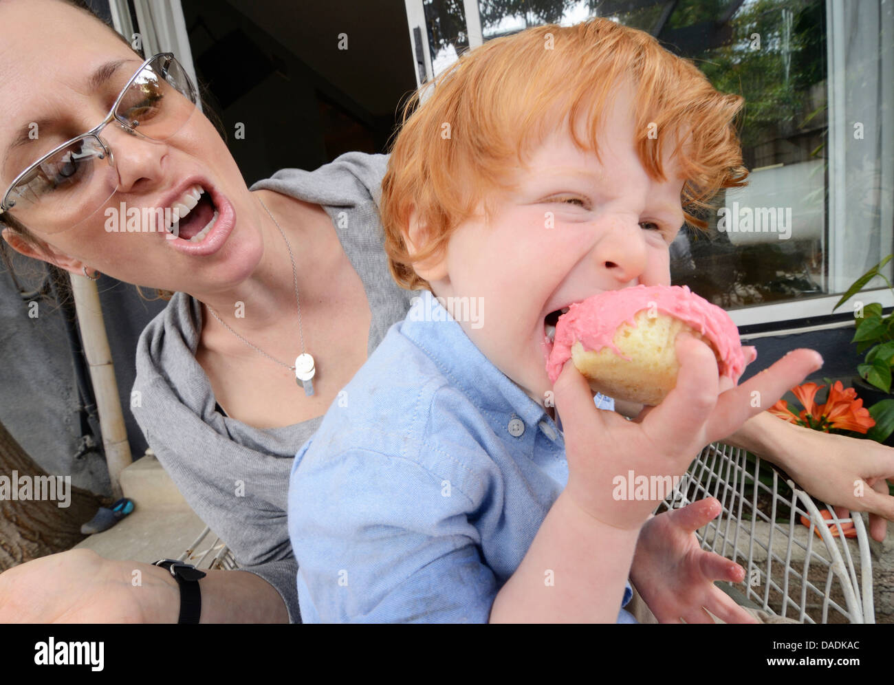 Mother with toddler eating pink covered cake Stock Photo