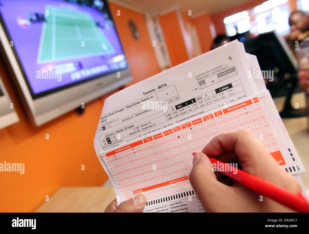 A customer fills out a ticket for betting on sports at a betting agency in Bielefeld, Germany, 28 October 2011. The German states, with the exception of Schleswig-Holstein, have agreed upon a new regulation of the billion euro worth gambling market. Photo: Oliver Krato Stock Photo