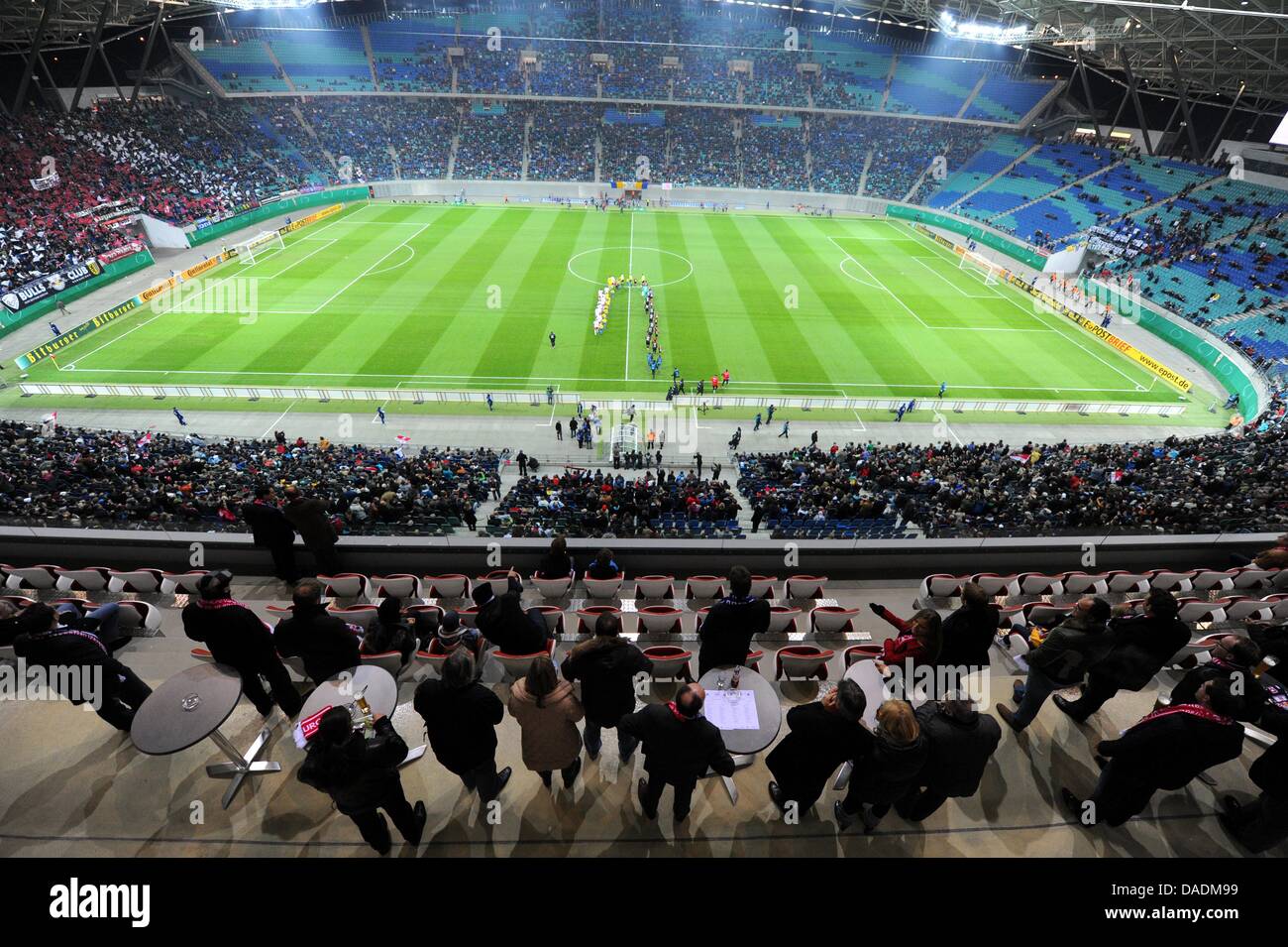 Die Zuschauer in den VIP-Bereichen (vorn) beobachten den Einlauf der Mannschaften, aufgenommen am Dienstag (25.10.2011) in der Red Bull Arena in Leipzig im Rahmen des DFB-Pokalspiels RB Leipzig gegen den FC Augsburg. Foto: Thomas Eisenhuth dpa Stock Photo