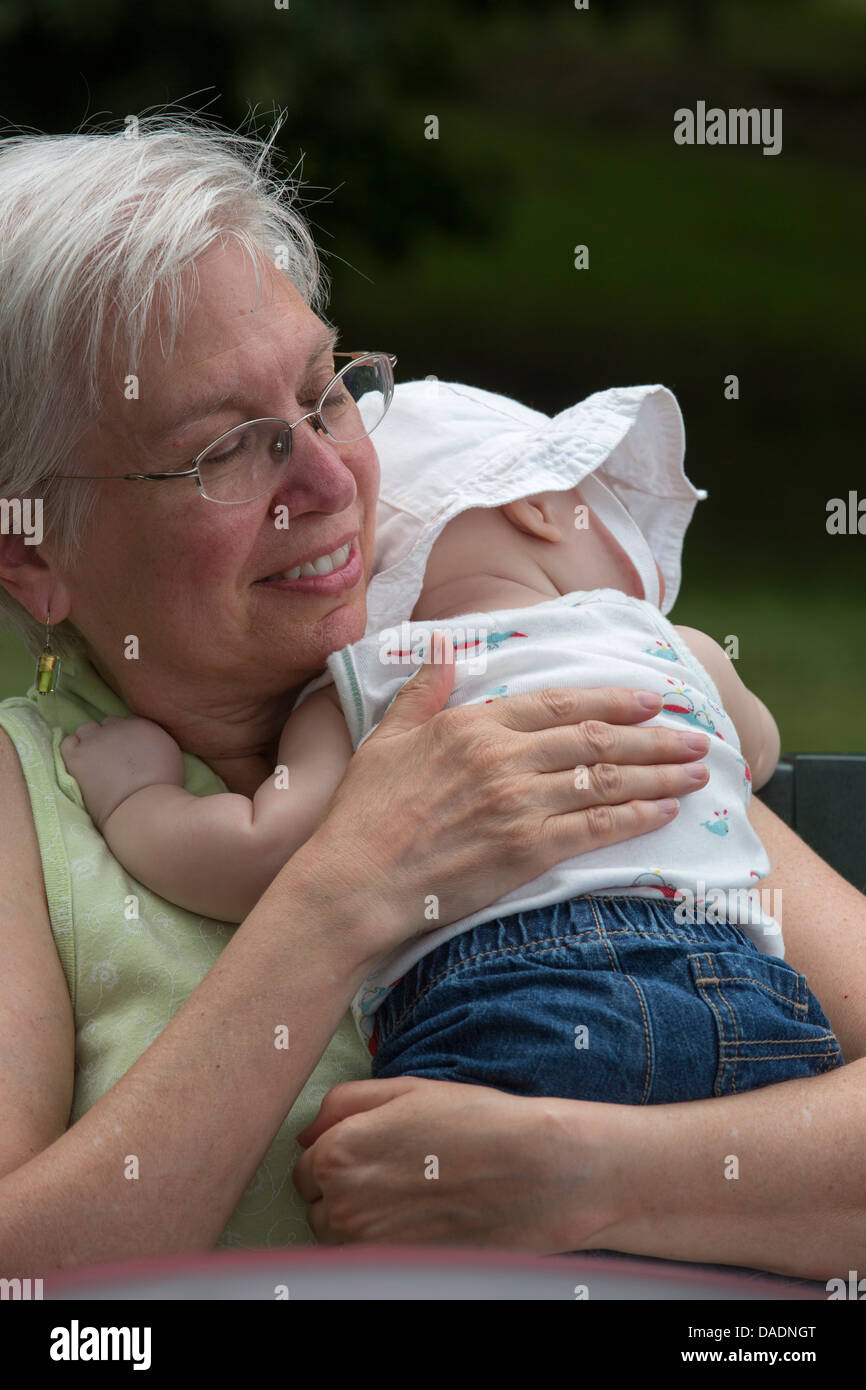 Lexington, Michigan - Susan Newell, 64, holds a friend's sleeping baby. Stock Photo