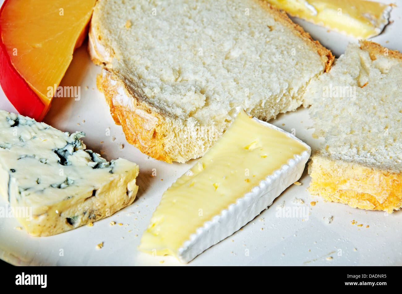 French Brie cheese with French blue cheese and Dutch Edam cheese and slices of white bread. Stock Photo