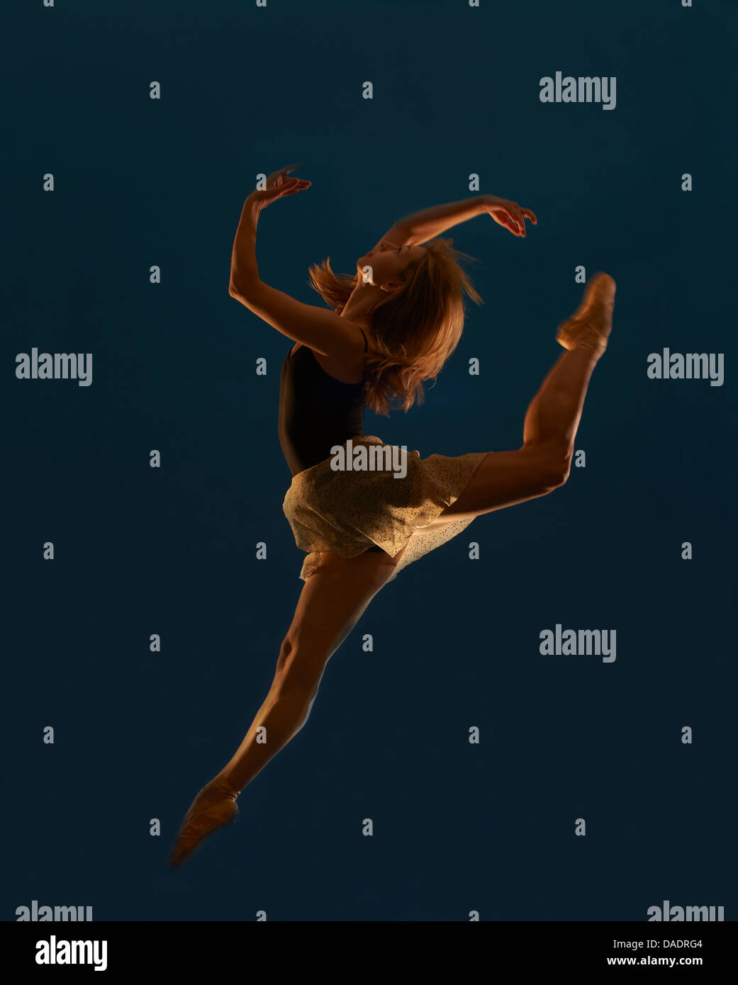 Young female dancer leaping mid air Stock Photo