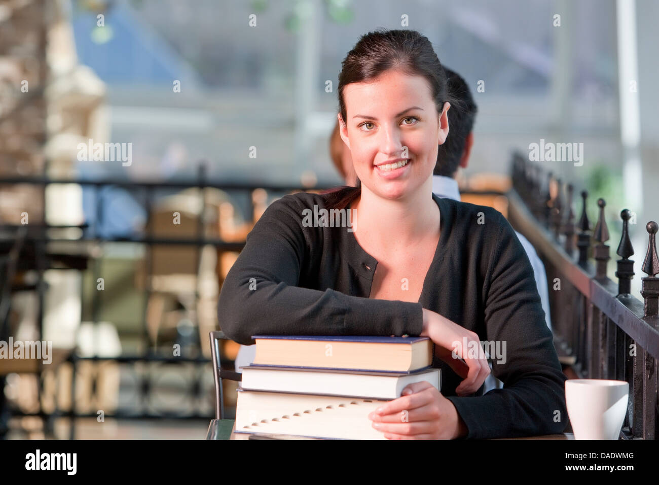 Young student leaning on stack of books, portrait Stock Photo - Alamy