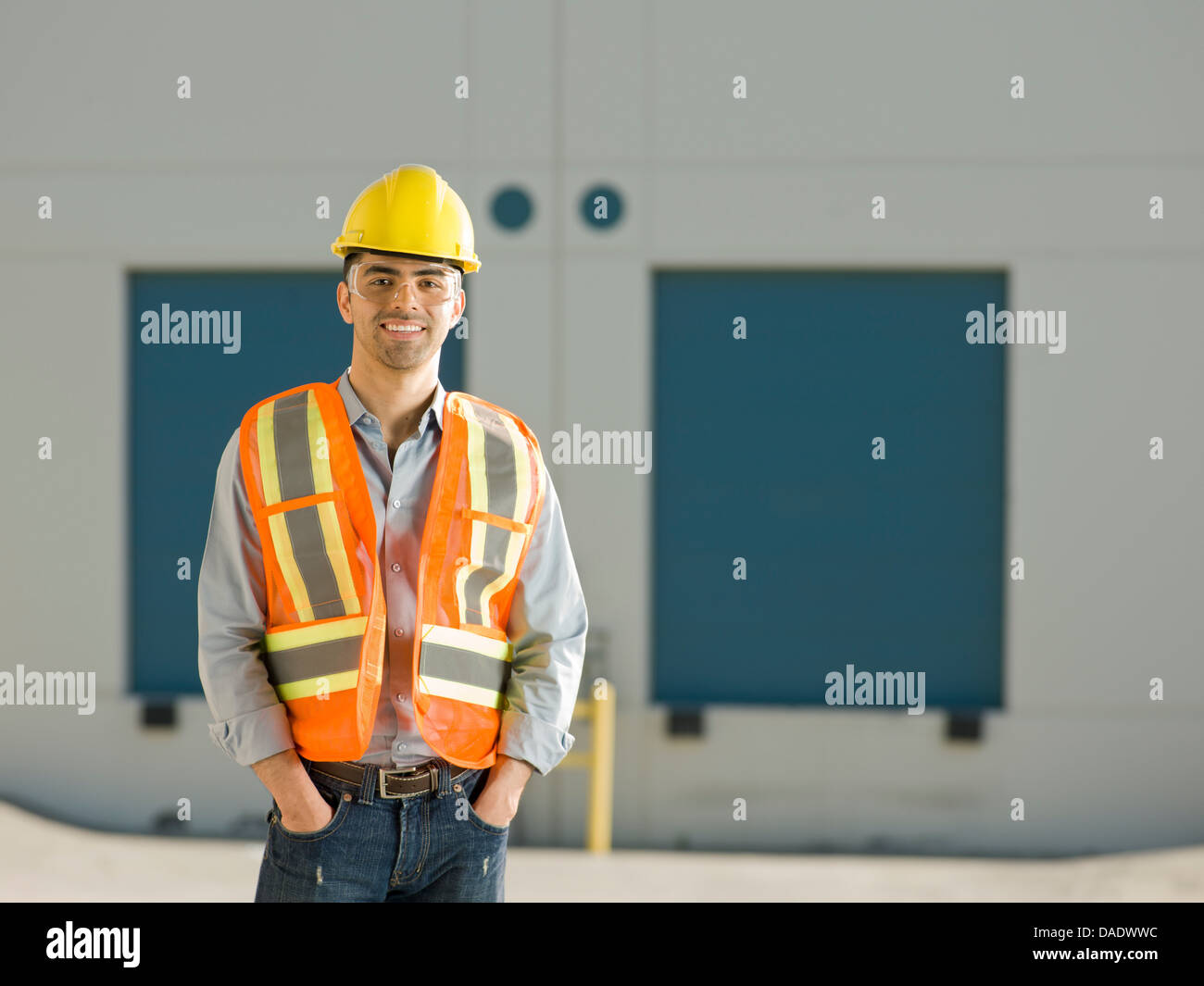 Mid adult construction worker with hand sin pockets, portrait Stock Photo