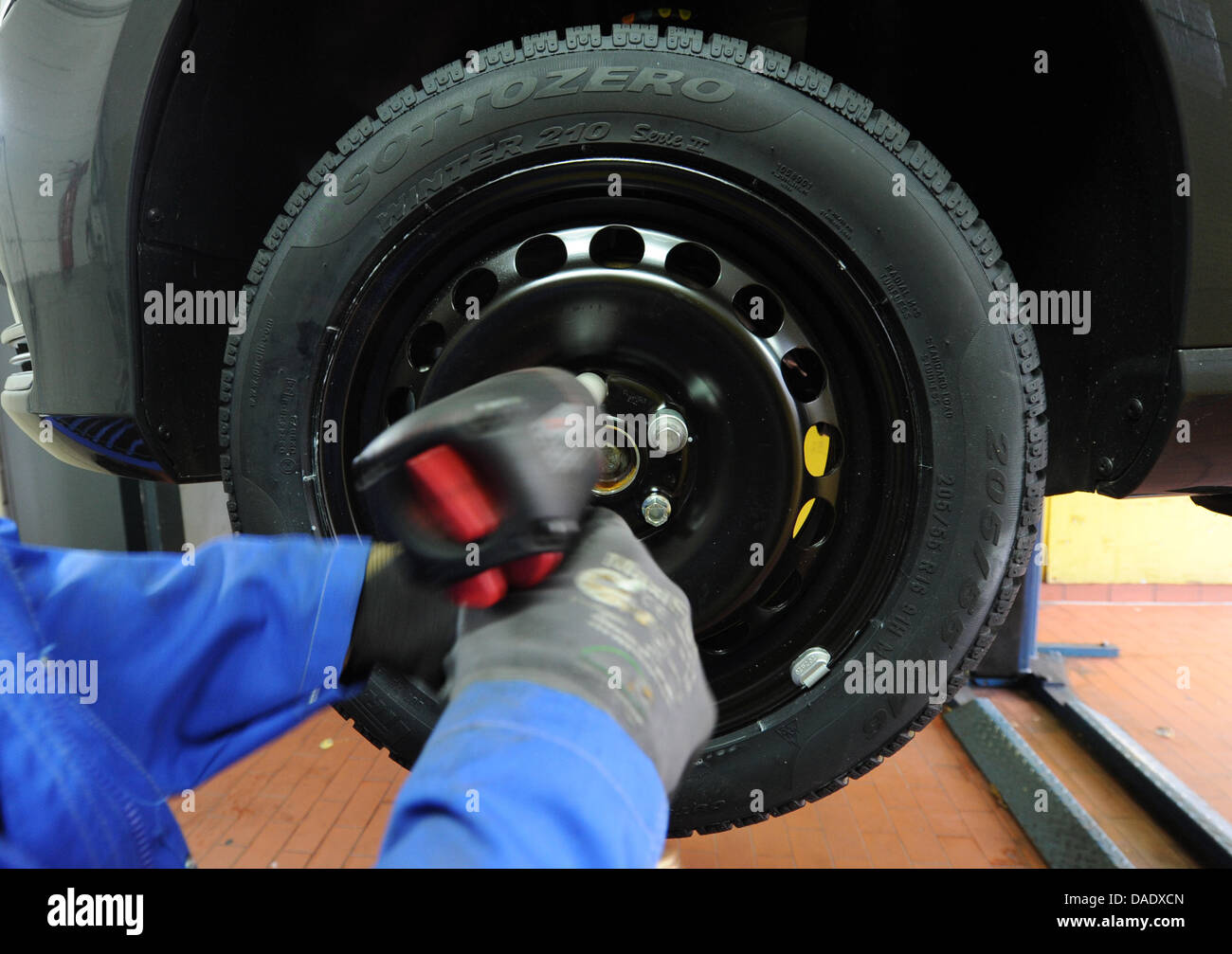 A mechanic mounts snow tires to a vehicle in Hamburg, Germany, 03