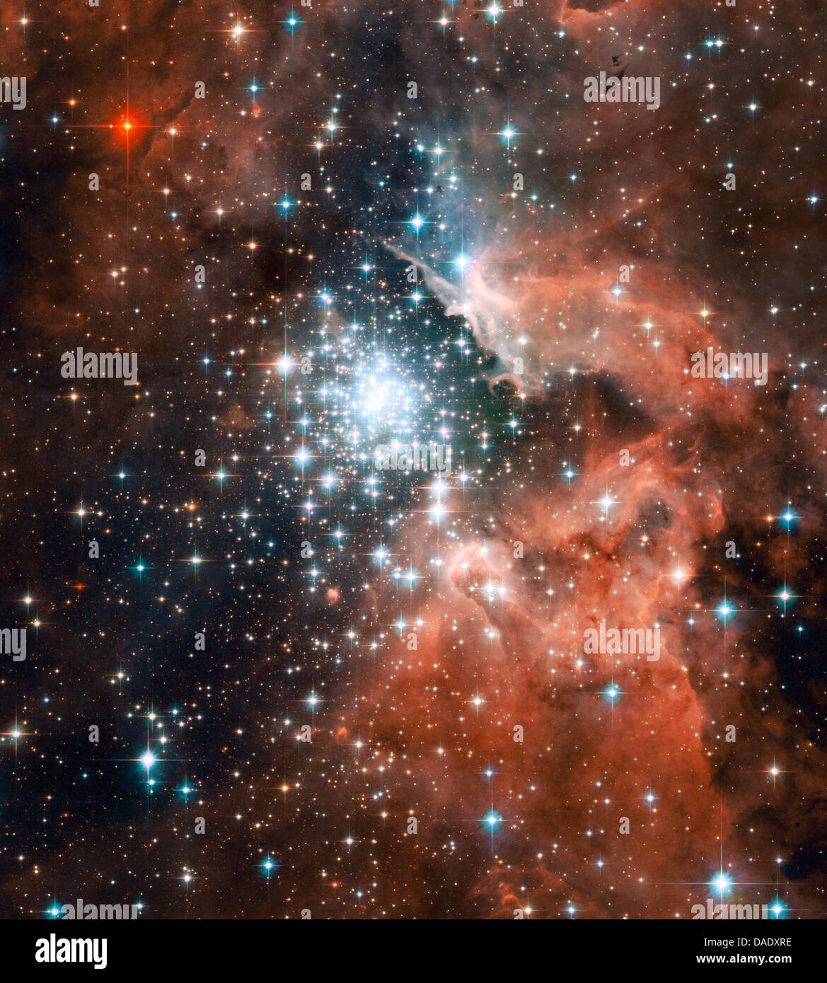 Thousands of sparkling young stars nestled within the giant nebula NGC 3603. This stellar 'jewel box' is one of the most massive young star clusters in the Milky Way Galaxy. NGC 3603 is a prominent star-forming region in the Carina spiral arm of the Milky Way, about 20,000 light-years away. This image shows a young star cluster surrounded by a vast region of dust and gas. The image Stock Photo