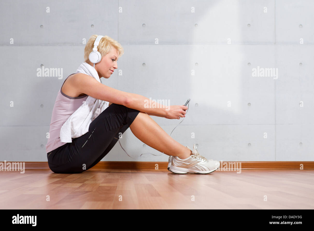 Germany, Brandenburg, Woman enjoying music with headphones Stock Photo