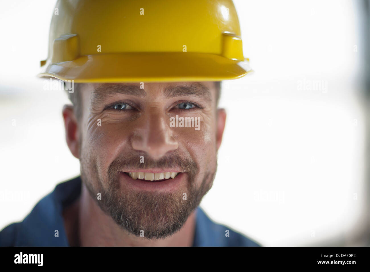 Mid adult construction worker wearing hard hat, smiling Stock Photo Alamy
