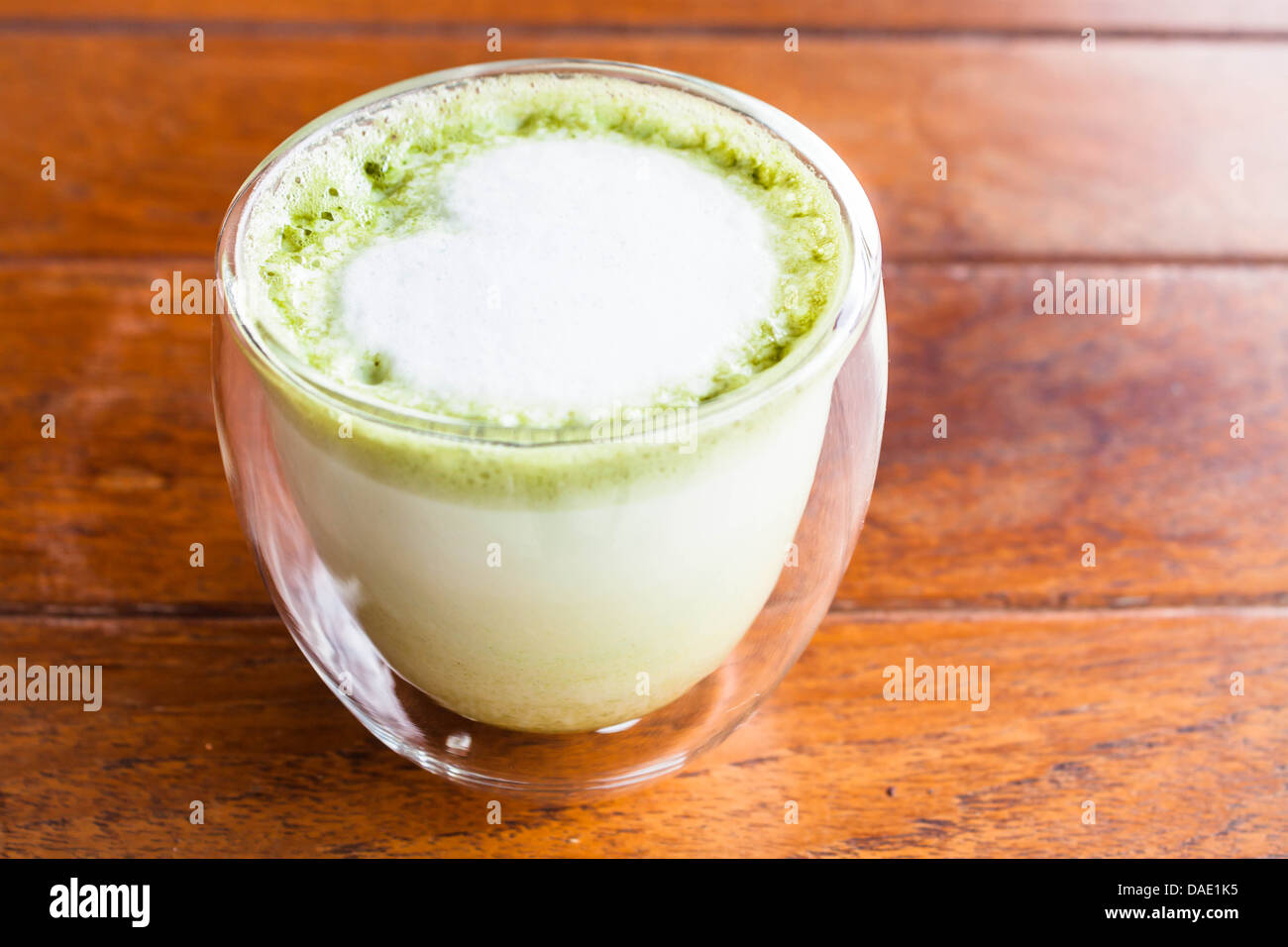 Glass of hot matcha green tea latte with milk microfoam Stock Photo