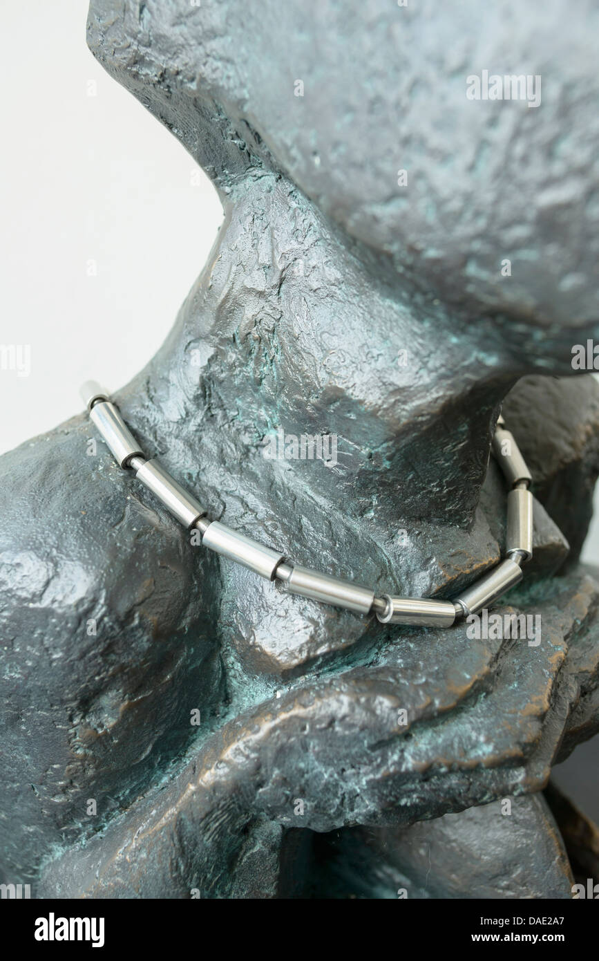 Silver and stainless steel necklace on neck of a sculpture, close up Stock Photo