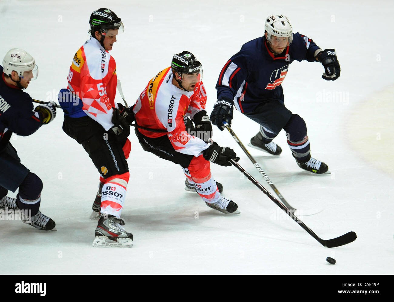 Swiss hockey players Dino Wieser (2nd L) and Daniel Rubin (2nd R) vie for  the pouck with US hockey player Noah Clarke (R) during the Deutschland Cup  ice hockey match between Switzerland
