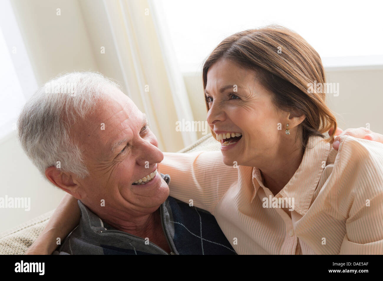 Mature woman and senior man hugging, laughing Stock Photo