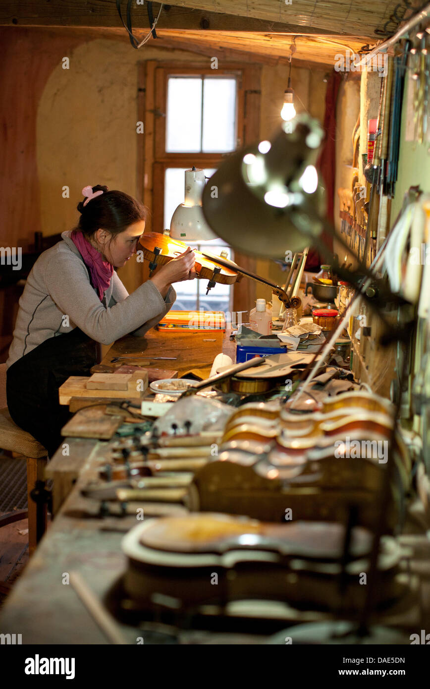 Instrument maker Kim Baker works on a violin inside her shop in Dresden