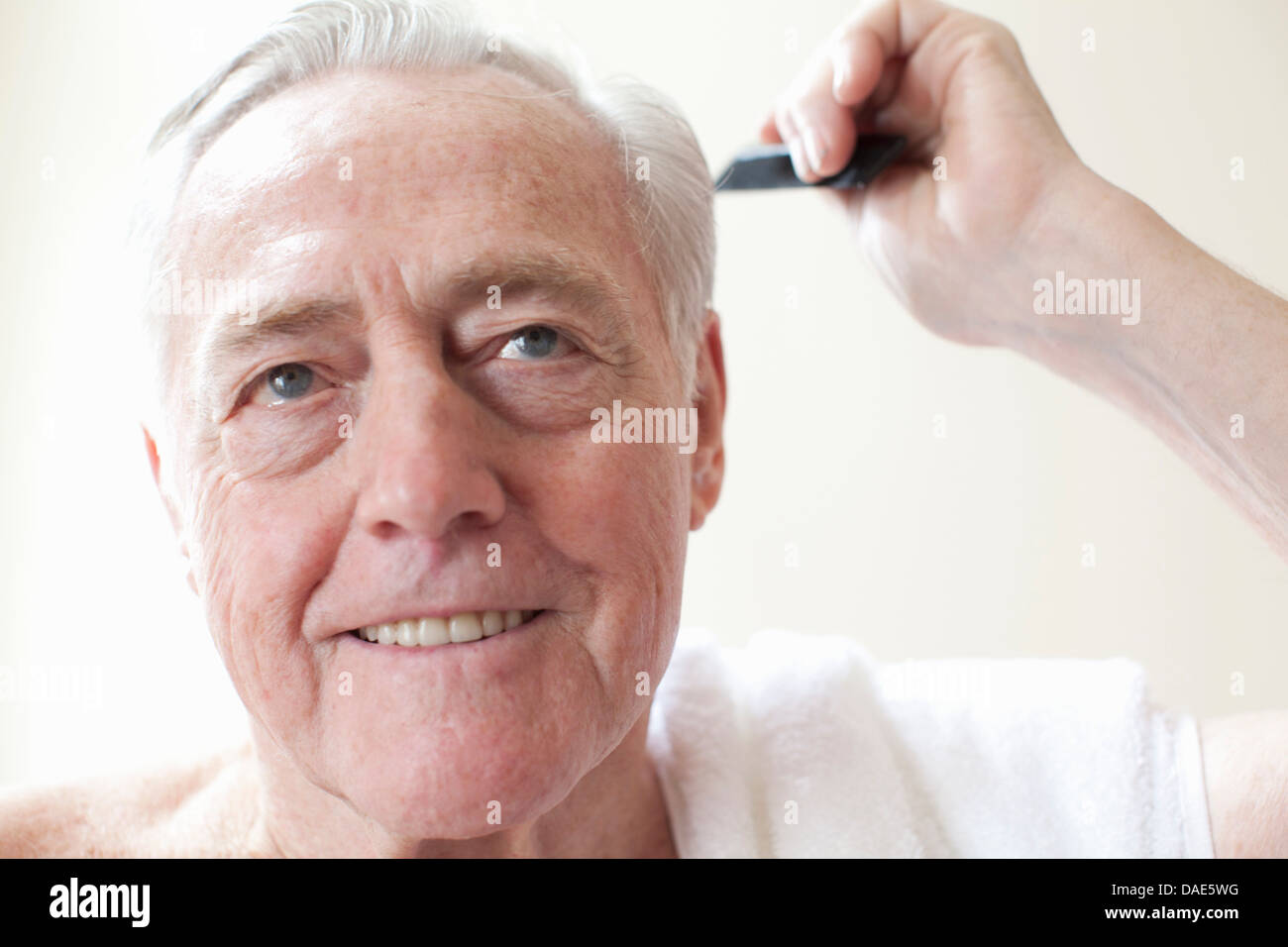 Senior man combing hair Stock Photo