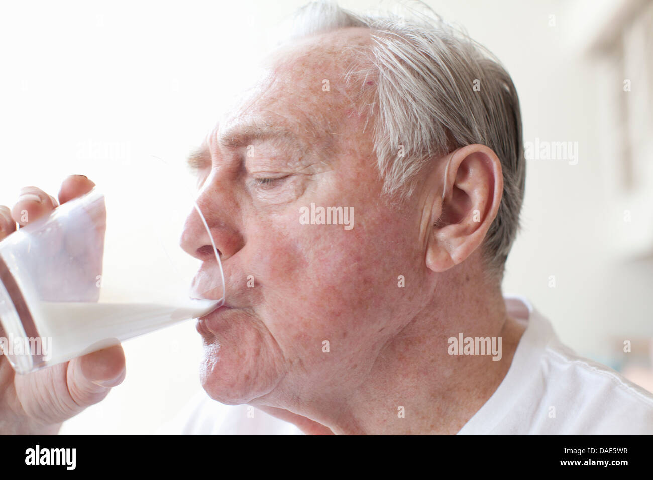 Senior man drinking glass of milk Stock Photo