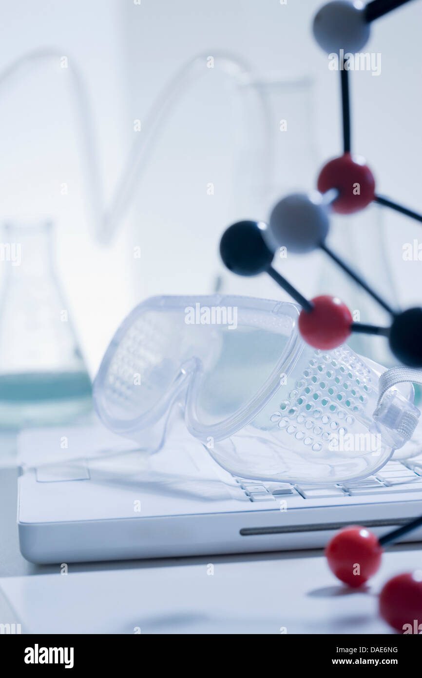 Safety goggles, atomic structure and laptop Stock Photo