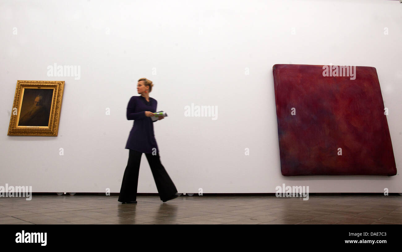 A visitor stands in between Gotthart Graubner's 'Color Space Bodies' from 1964 (R) and Jan Lieven's 'Portrait of a Man' from 1630 (L) at the State Museum in Schwerin, Germany, 16 November 2011. The museum is presenting a large exhibition on the dutch old masters as forerunners of abstract art in the 20th and 21st centuries from Friday. Ten contemporary painters and installation art Stock Photo