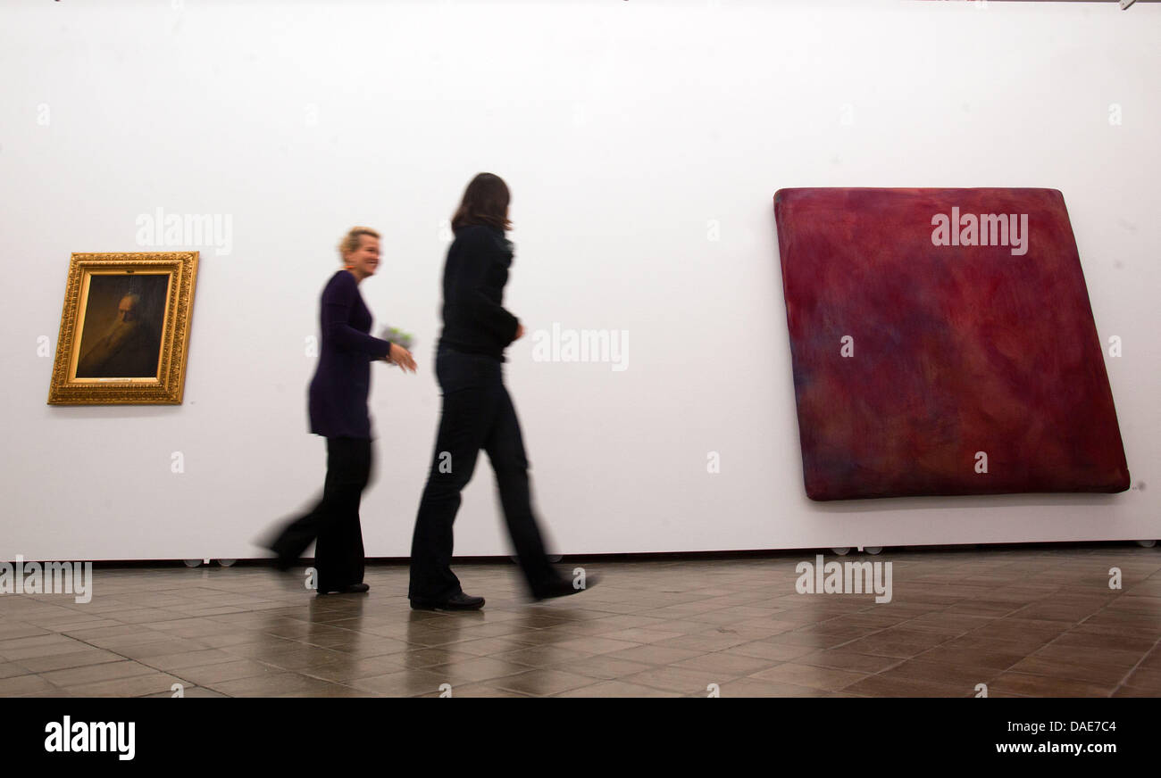 Visitors walk between Gotthart Graubner's 'Color Space Bodies' from 1964 (R) and Jan Lieven's 'Portrait of a Man' from 1630 (L) at the State Museum in Schwerin, Germany, 16 November 2011. The museum is presenting a large exhibition on the dutch old masters as forerunners of abstract art in the 20th and 21st centuries from Friday. Ten contemporary painters and installation artists a Stock Photo