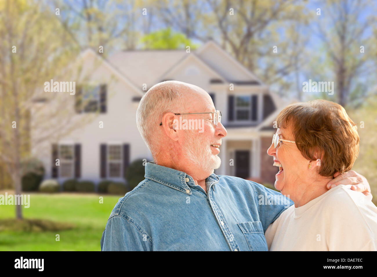 Happy Senior Couple in the Front Yard of Their House. Stock Photo