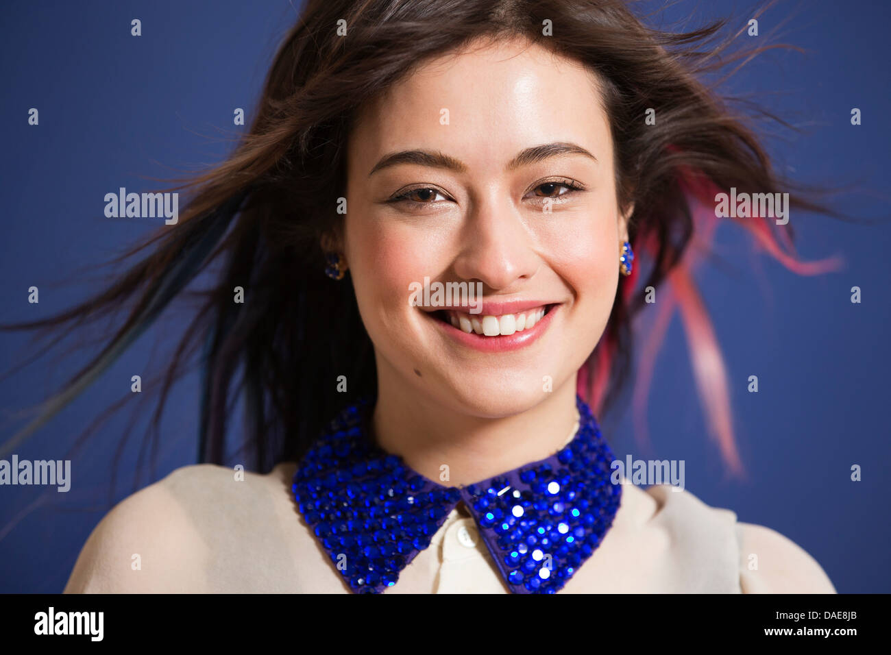Portrait of young woman with dyed hair and blue sequin collar Stock Photo