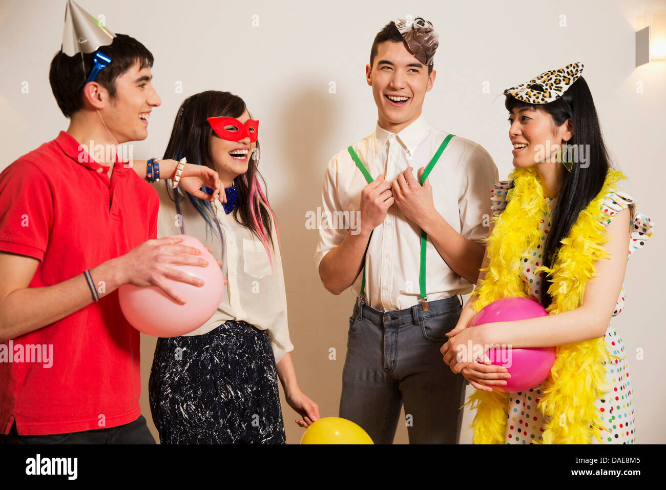 Friends at a party with balloons, studio shot Stock Photo