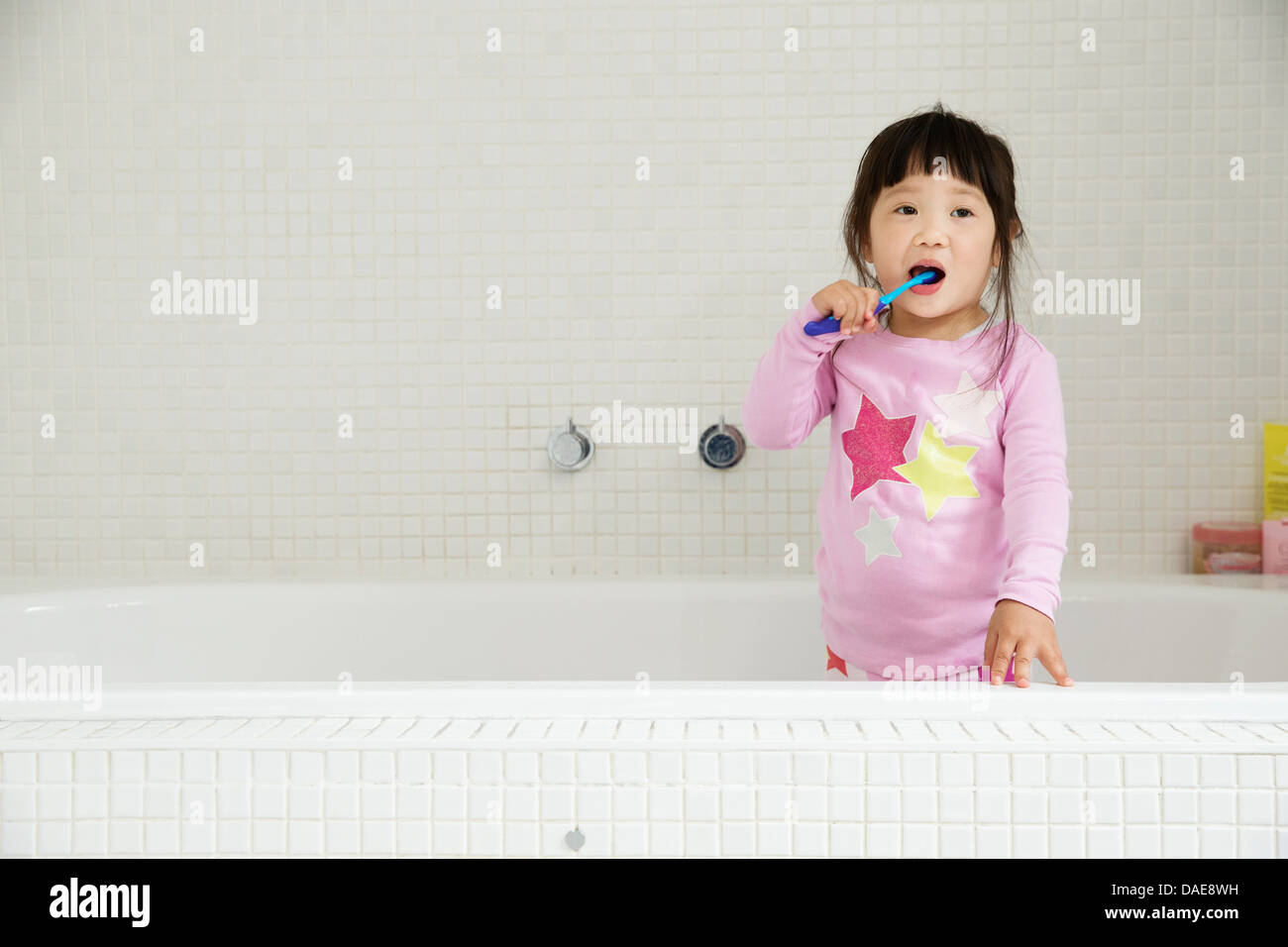 Female toddler standing in bath brushing teeth Stock Photo Alamy