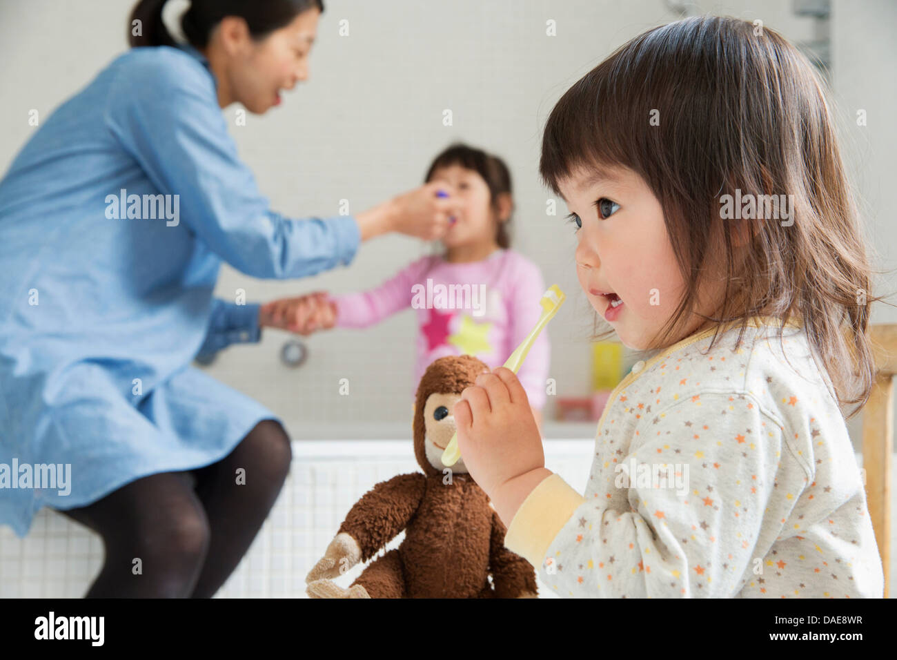 Female toddler with cuddly toy and toothbrush Stock Photo