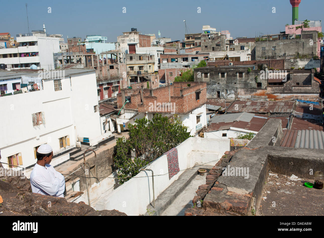 A young islamic student admires the view across the old city of Dhaka from the roof of a Madras or religious school in the heart Stock Photo