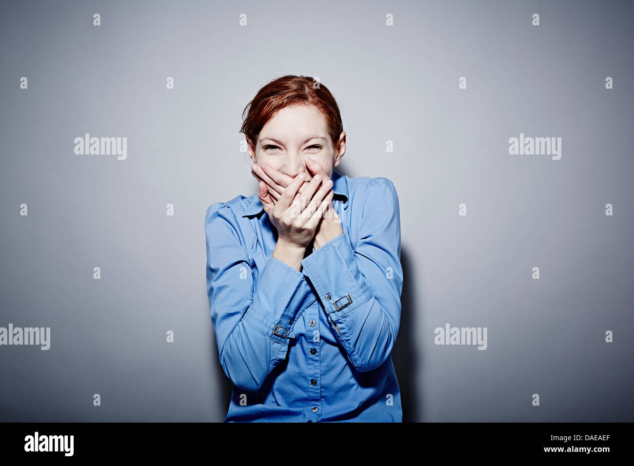 Studio portrait of young woman giggling Stock Photo