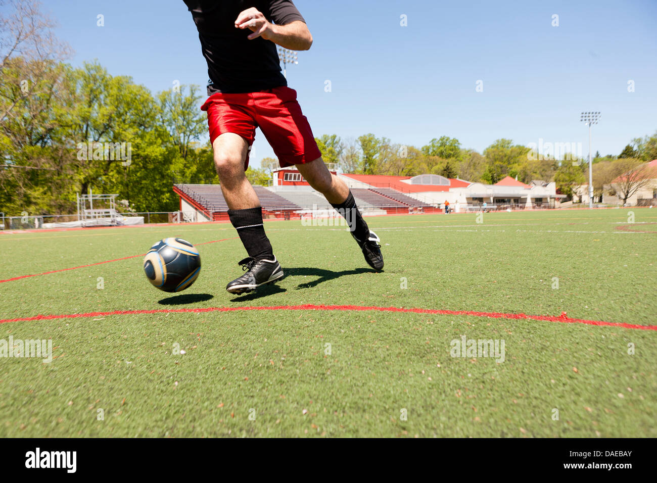 Soccer player running down pitch with ball Stock Photo Alamy