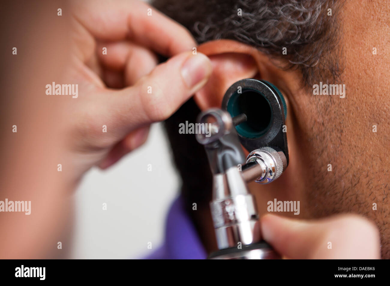 Mid adult doctor using otoscope on patient Stock Photo Alamy
