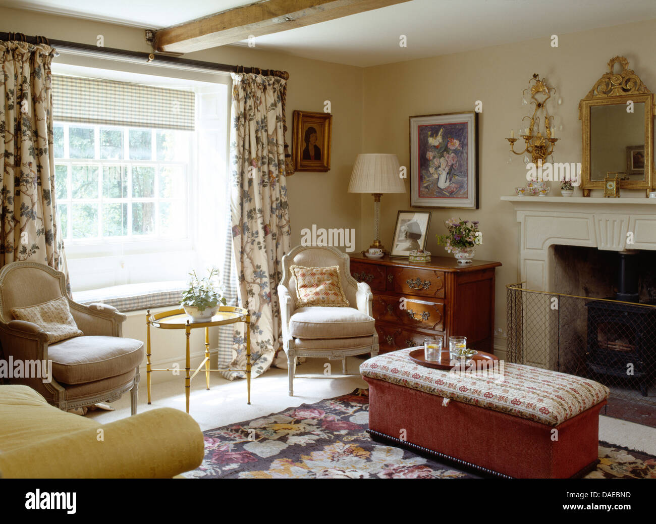 Patterned ottoman in front of fireplace in cottage sitting room with