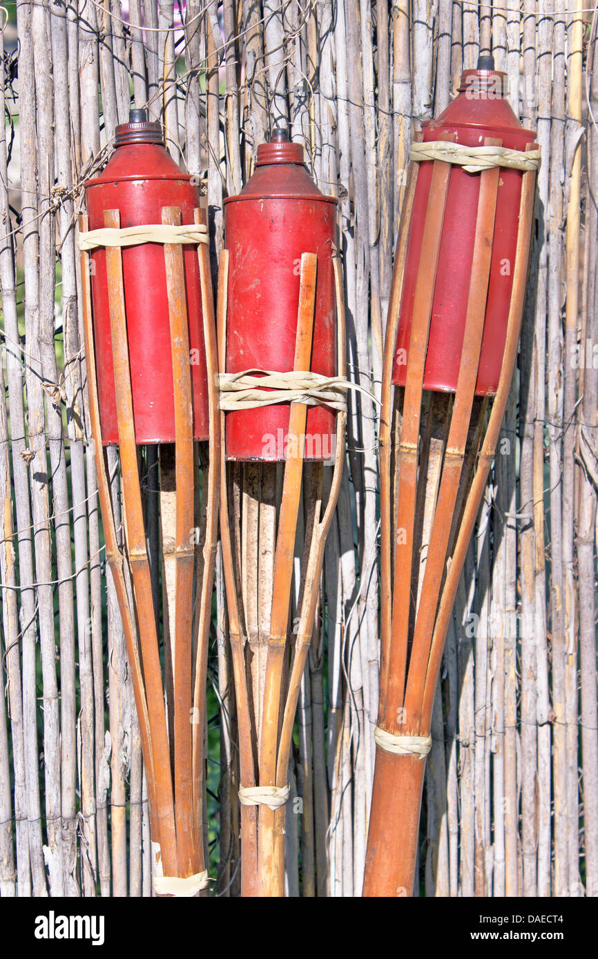 Three bamboo fire torch on cane fence Stock Photo