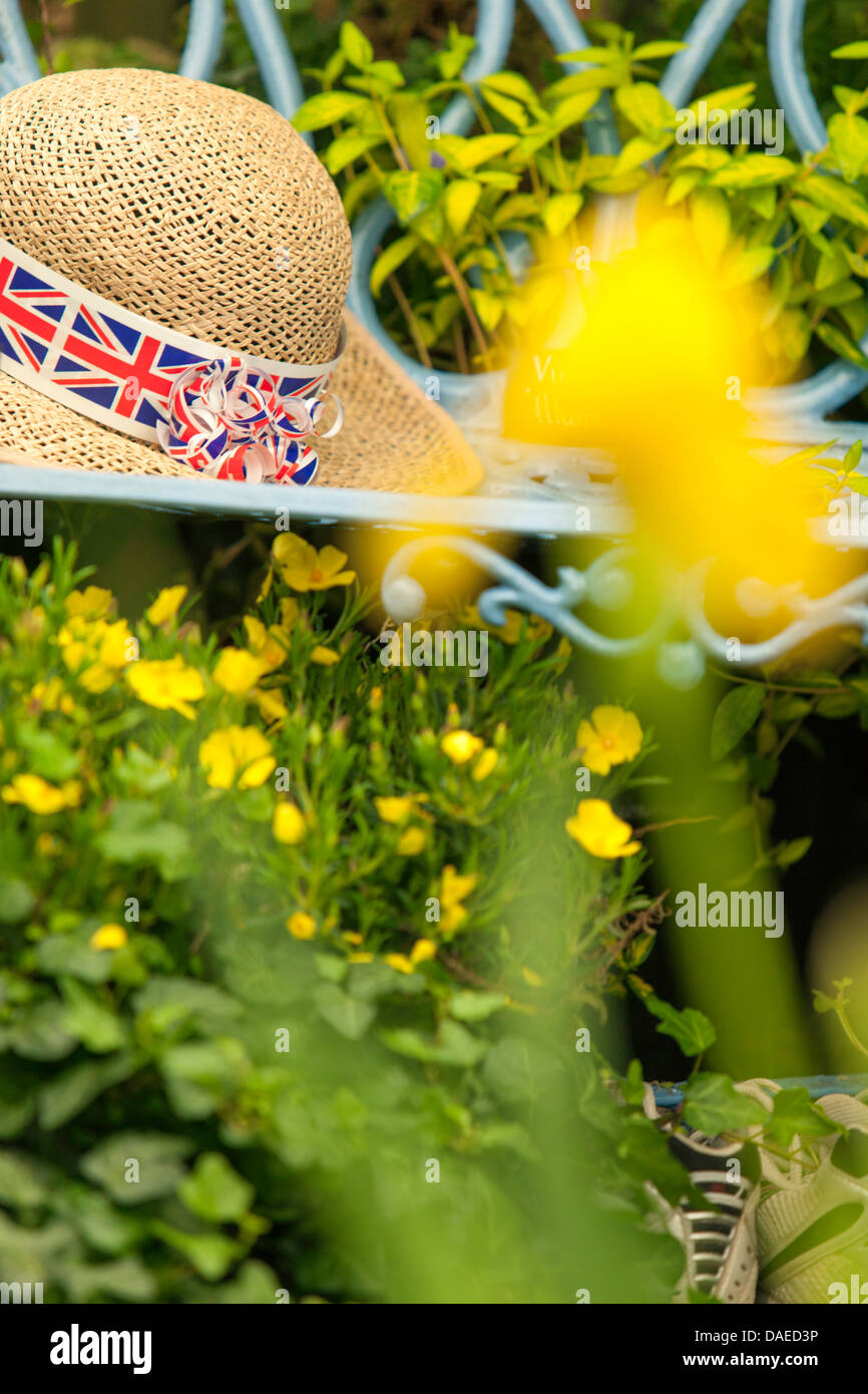 Ladies straw hat with union jack band in cottage garden, England, UK