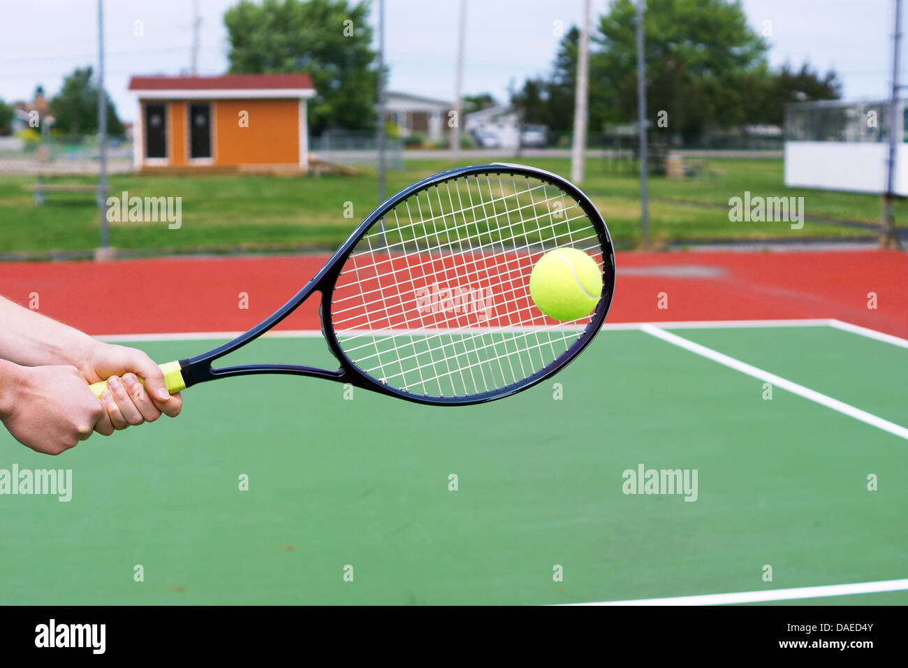 Player hands on tennis racket hitting a back hand volley Stock Photo