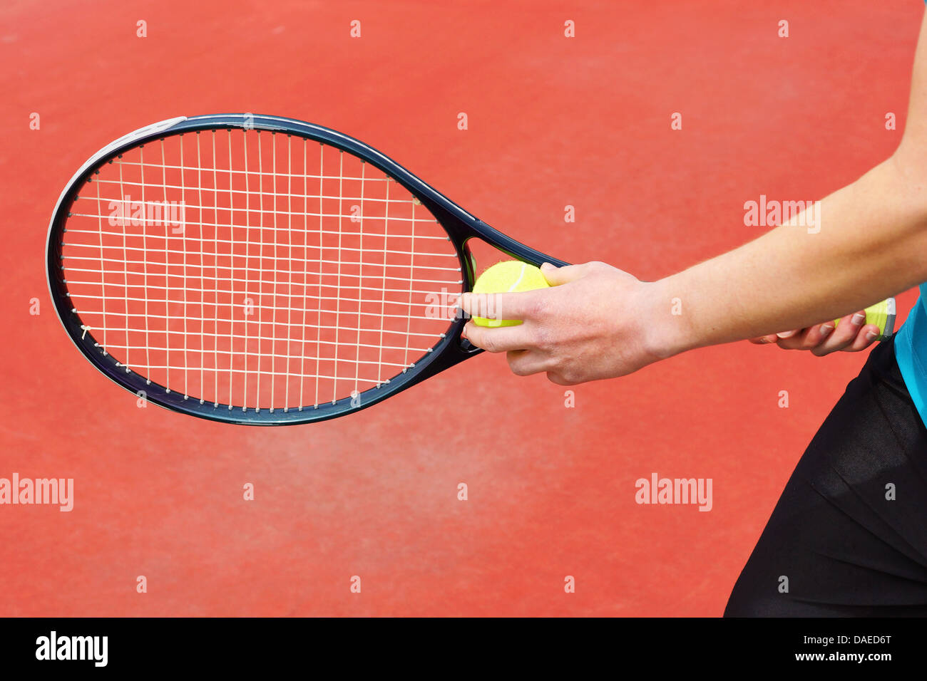 Player on hard court ready to serve the tennis ball with racket Stock Photo