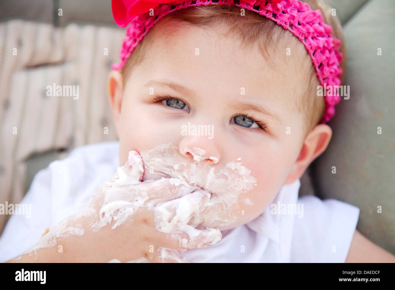 Young Girl with Cake Frosting on Face Stock Photo