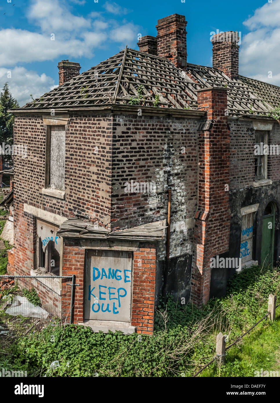 Abandoned and boarded up old house with missing roof tiles along Chapel
