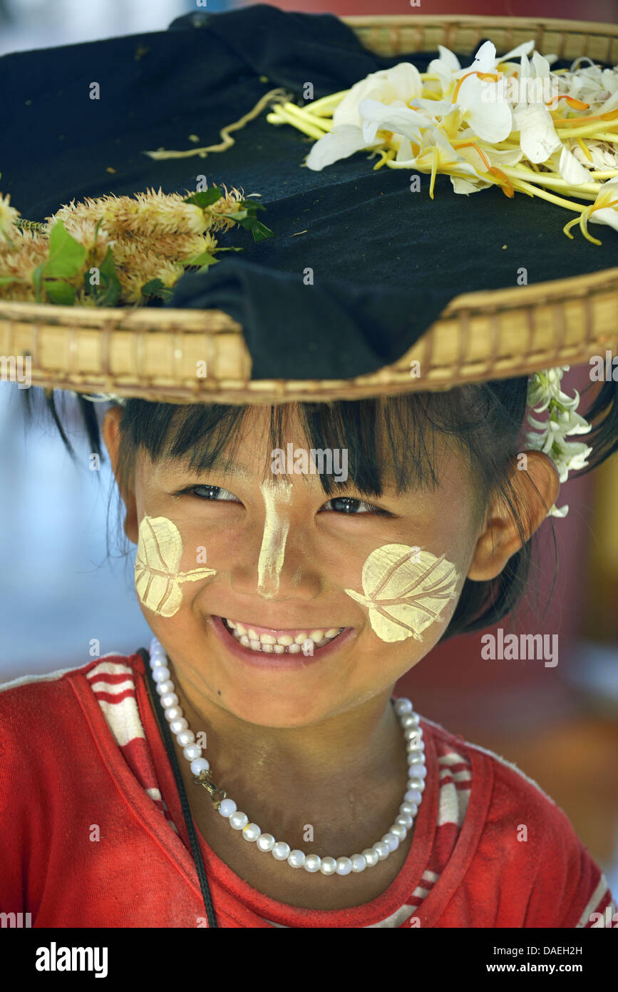 little flower seller made up with the traditional Burmese thanaka, a sun protection paste made of the thanaka tree, Burma, Mandalay Stock Photo