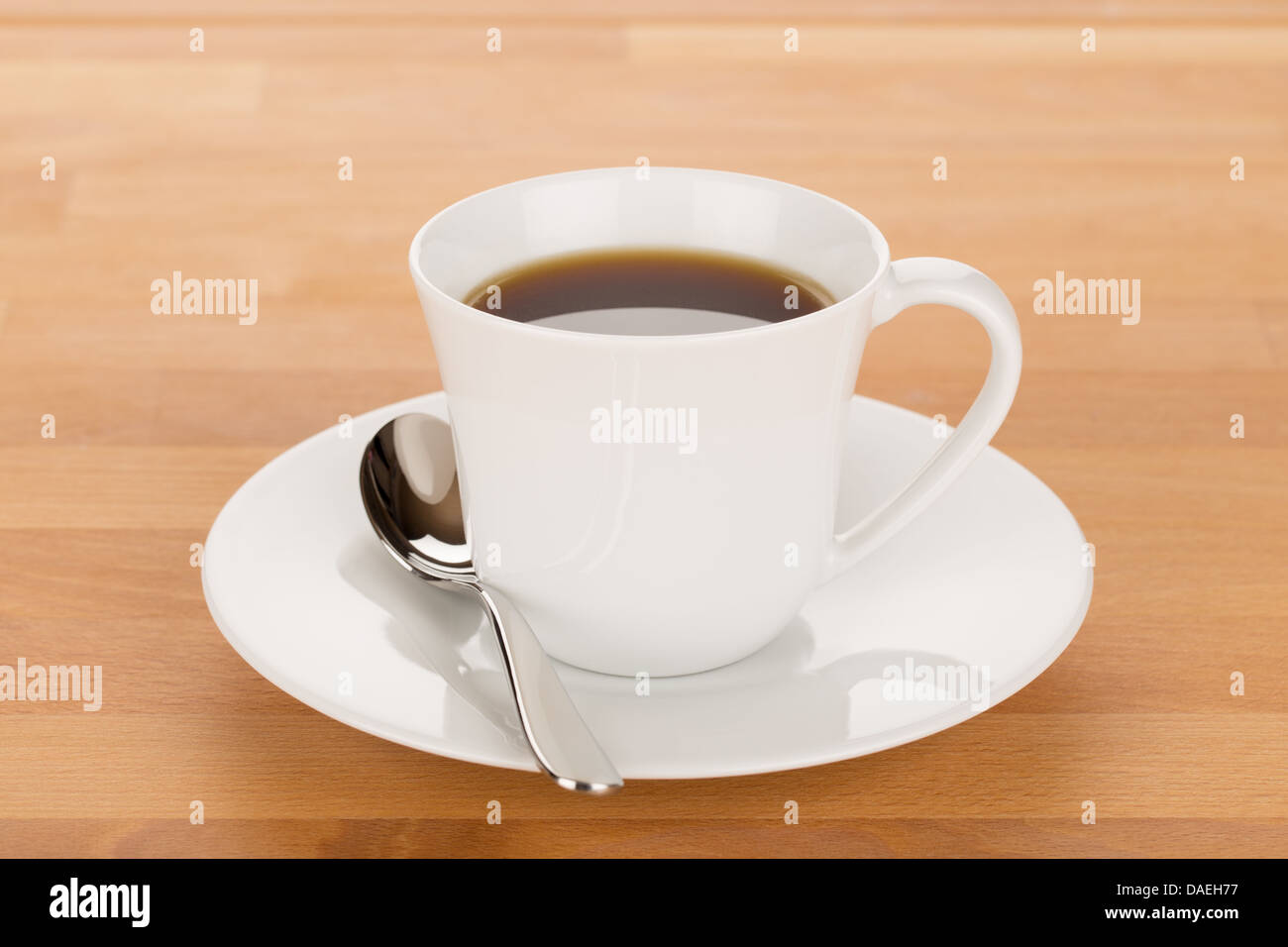 Cup of coffee and silver spoon on wooden table close up. Stock Photo