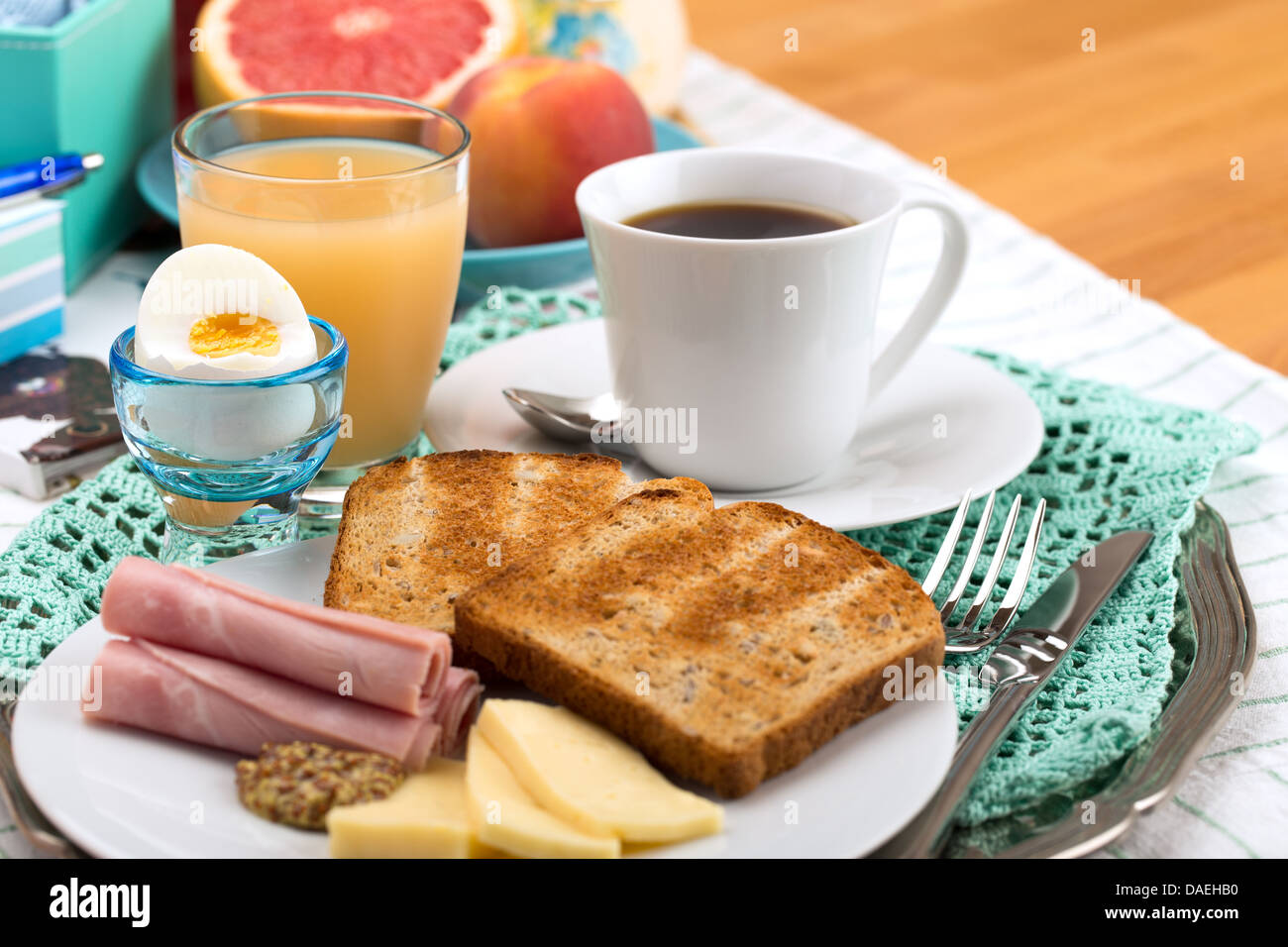 Breakfast with toast, ham, cheese, egg, grapefruit, juice and cup of