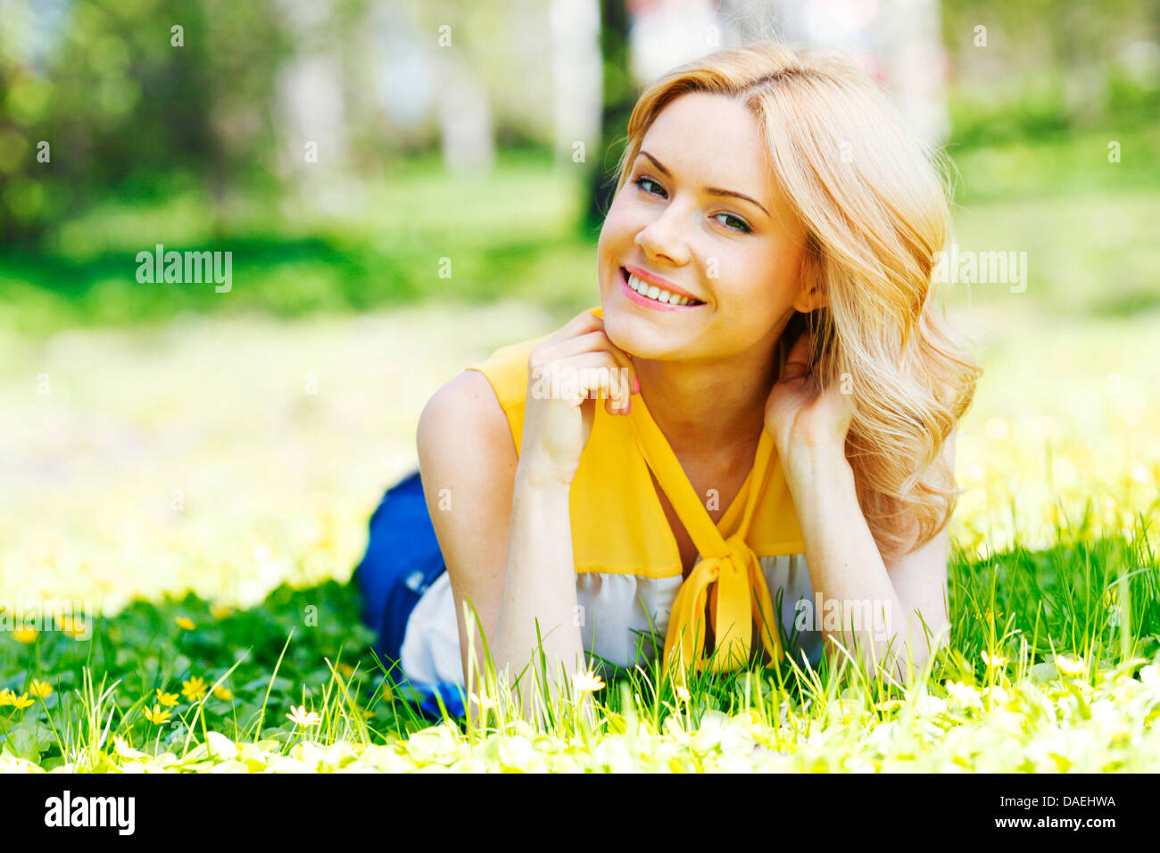 Happy young woman lying on grass Stock Photo - Alamy